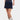 Person wearing a navy polka dot skort with a white background